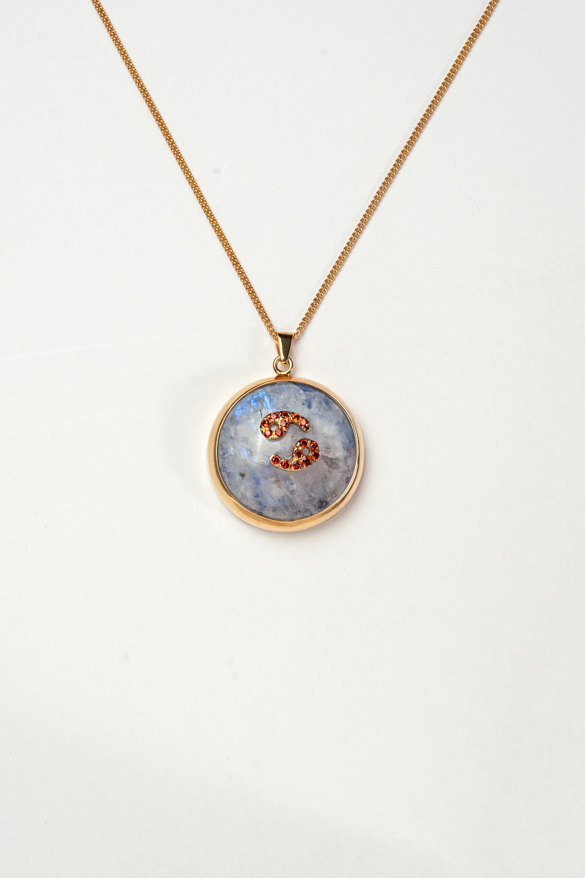 Cancer zodiac pendant: moonstone cabochon and red garnets.

Amuleto de Cáncer: piedra luna cabujón y granates rojos.