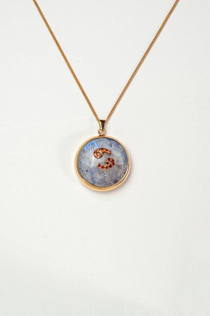 Cancer zodiac pendant: moonstone cabochon and red garnets.

Amuleto de Cáncer: piedra luna cabujón y granates rojos.