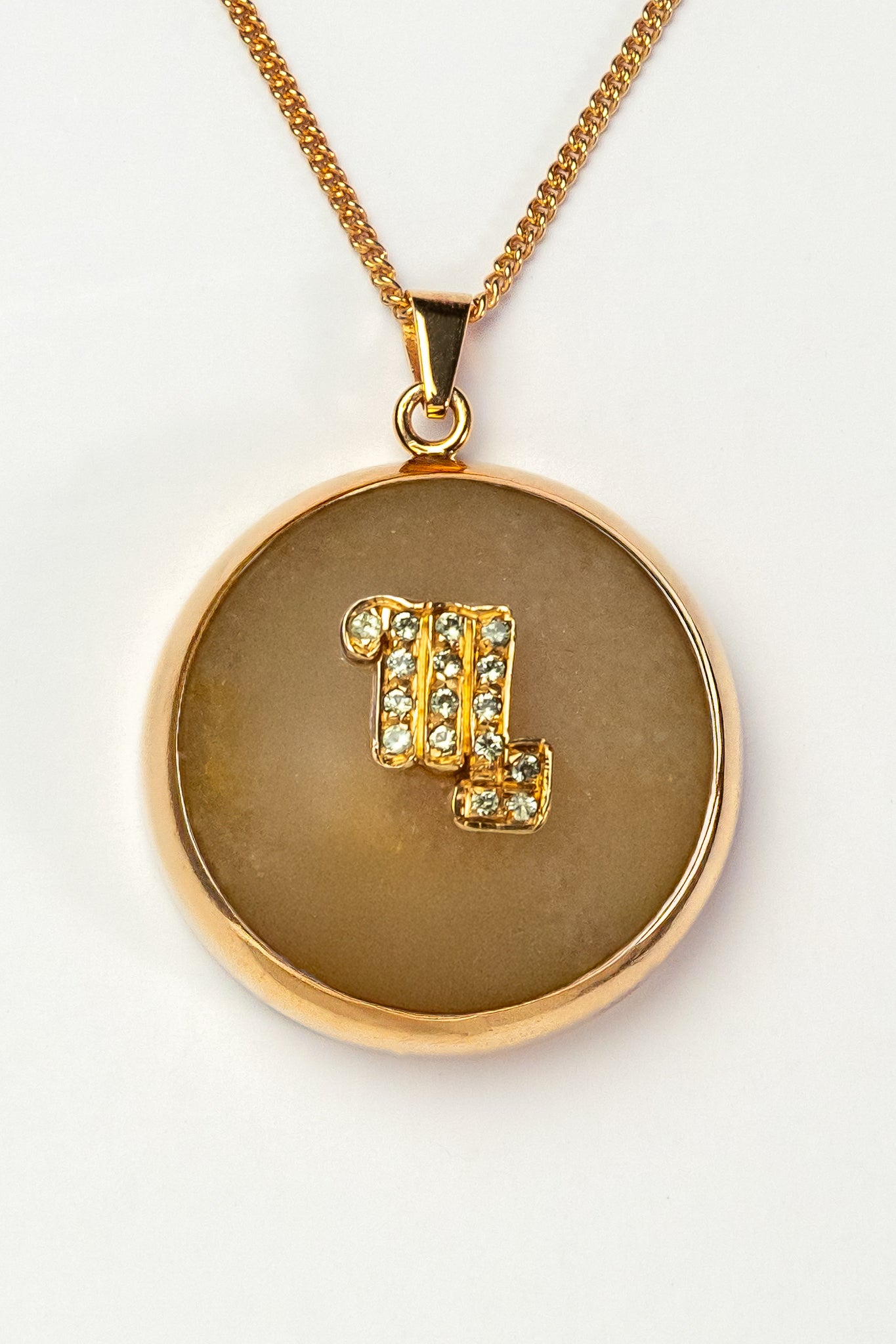 Scorpio zodiac pendant: yellow jade cabochon and peridot.

Amuleto de Escorpio: jade amarillo cabujón y peridoto.