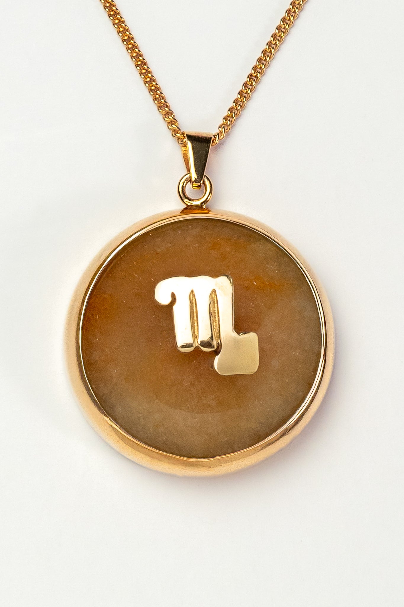 Scorpio zodiac pendant: yellow jade cabochon and peridot.

Amuleto de Escorpio: jade amarillo cabujón y peridoto.