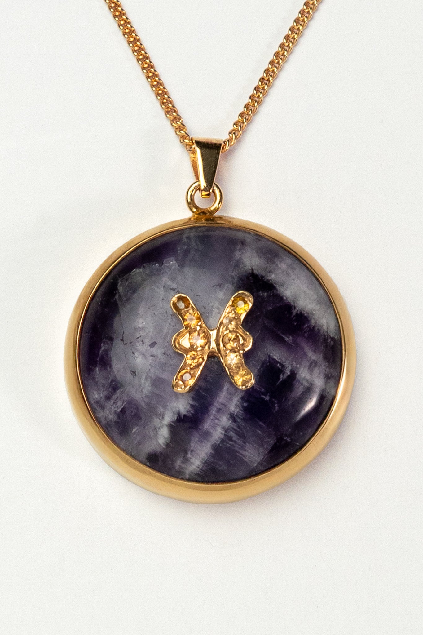 Pisces zodiac pendant: Amethyst cabochon and yellow sapphires.

Amuleto de Piscis Amatista cabujón y zafiros amarillos.