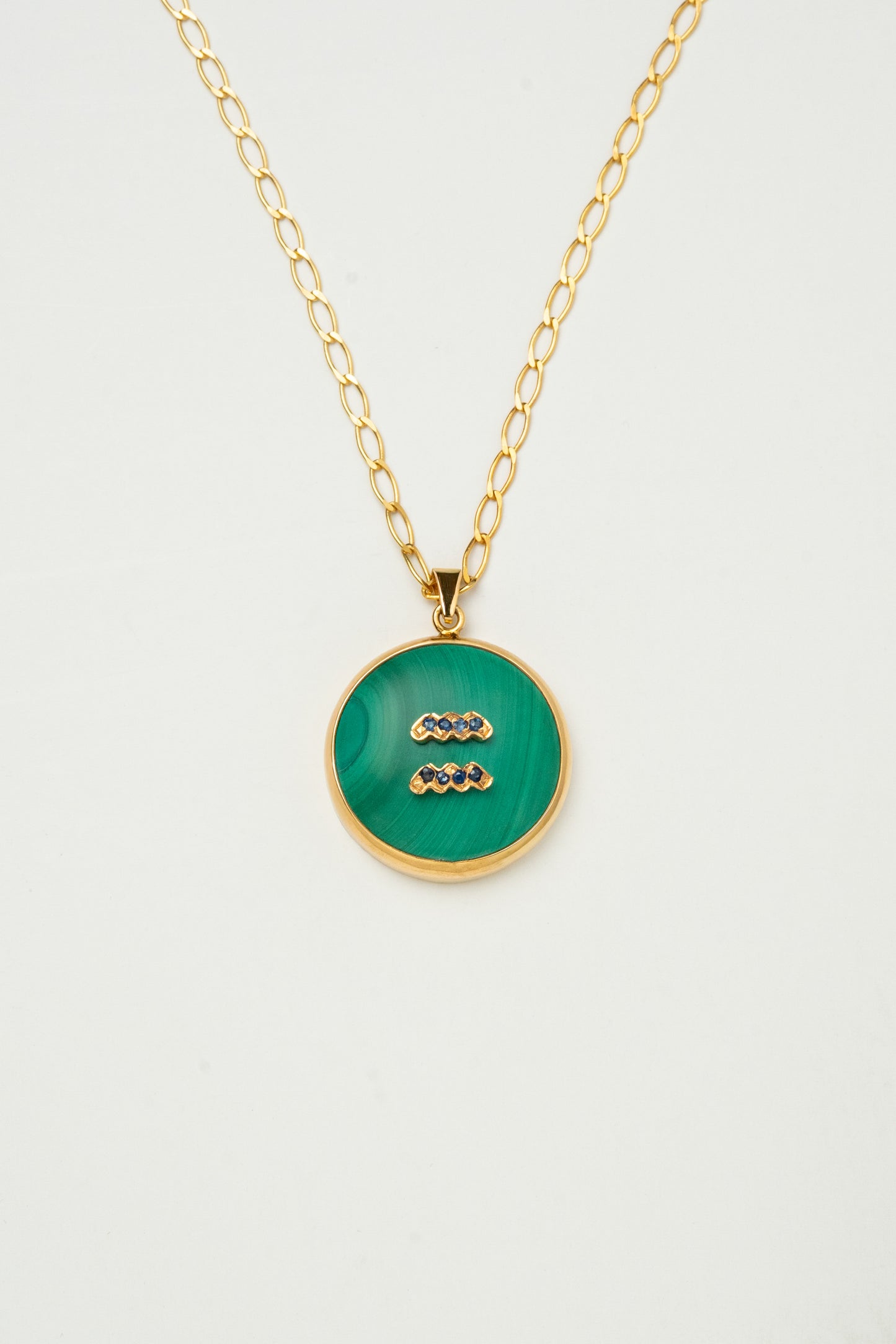 Aquarius zodiac pendant: malachite cabochon and blue sapphire.

Amuleto de Acuario: malaquita cabujón y zafiro azul.