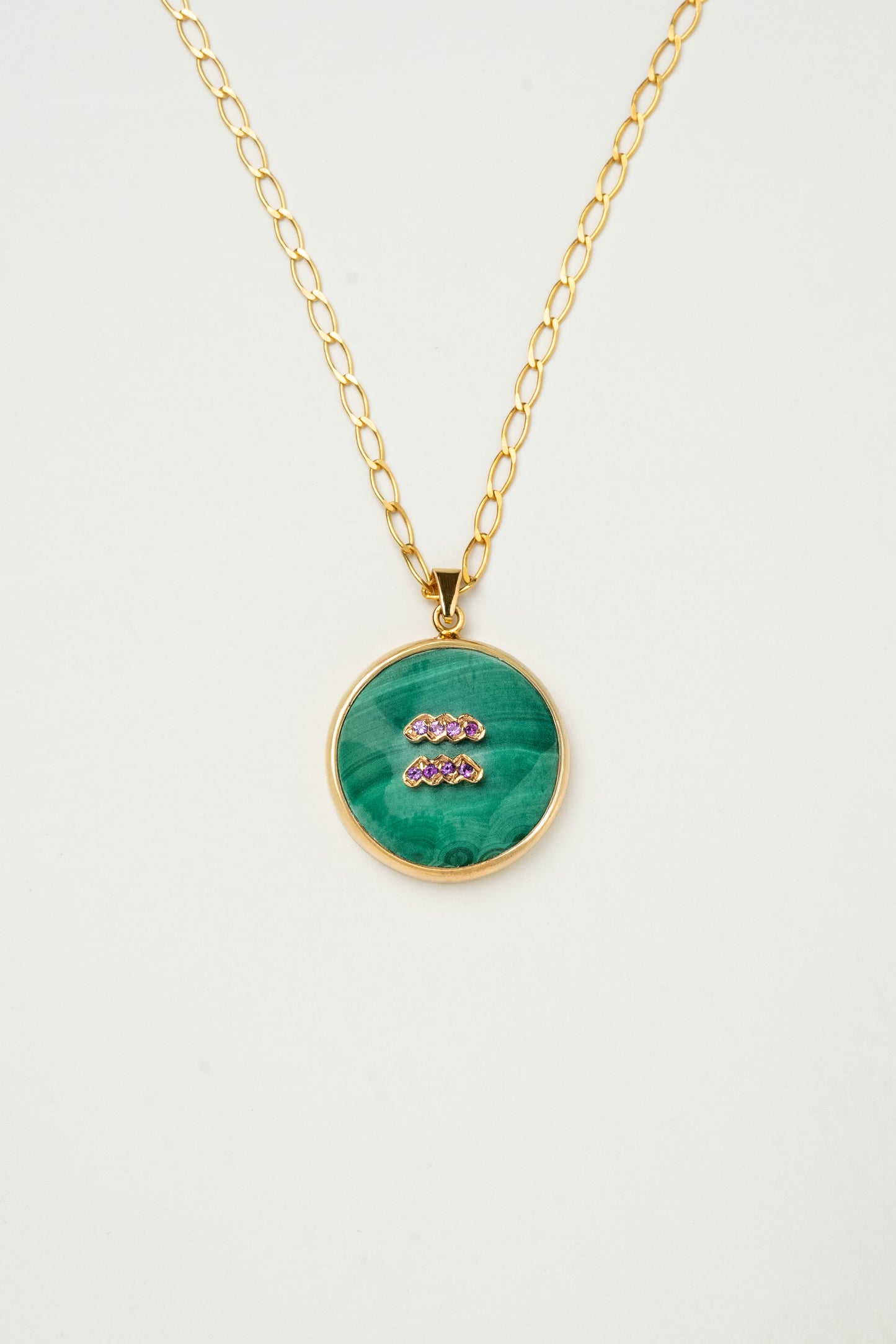 Aquarius zodiac pendant: malachite cabochon and amethyst.

Amuleto de Acuario: malaquita cabujón y amatista.