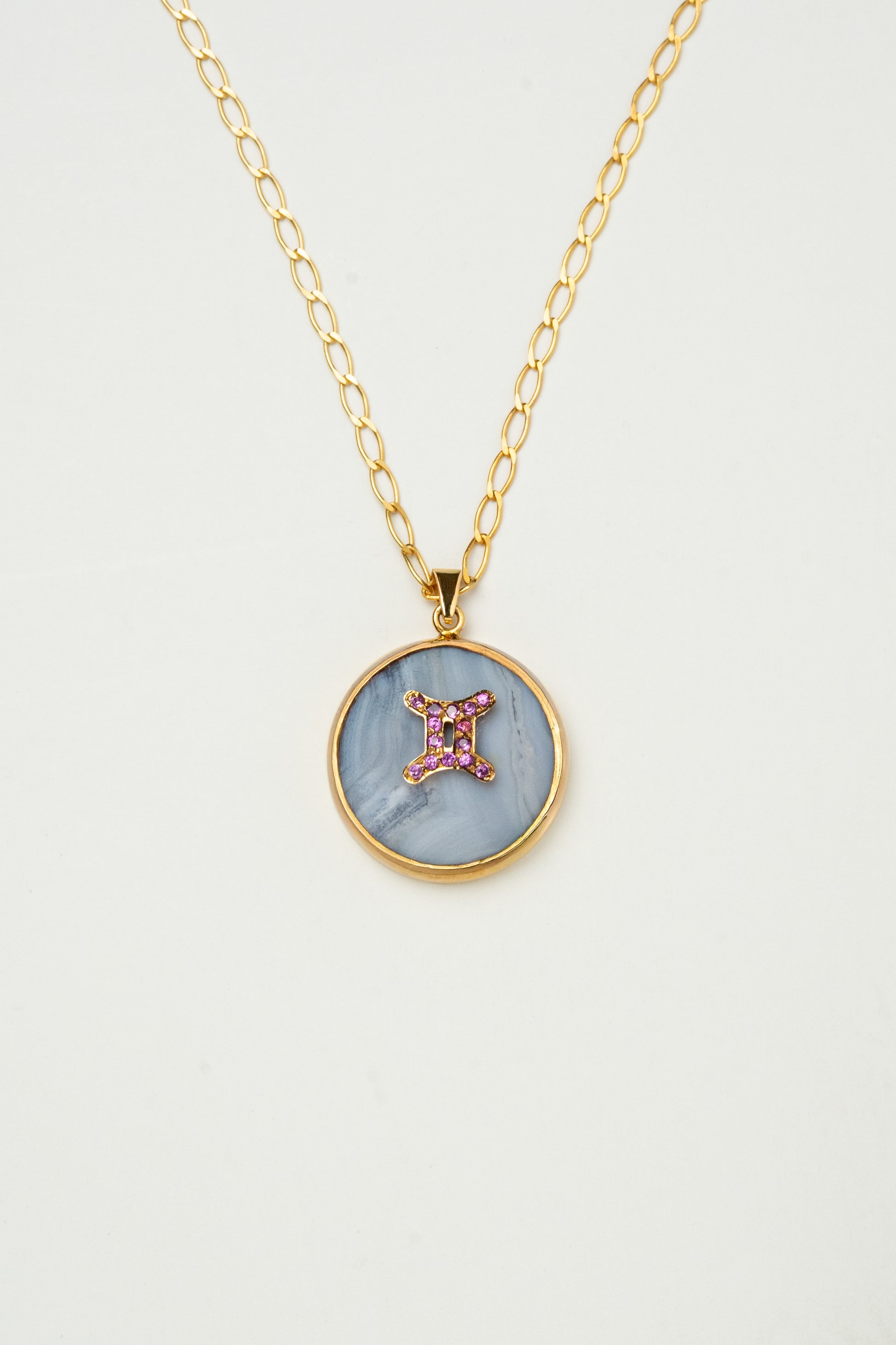 Gemini zodiac pendant: blue lace agate cabochon and pink spinel.

Amuleto e Géminis: ágata de encaje azul cabujón y espinela rosa.