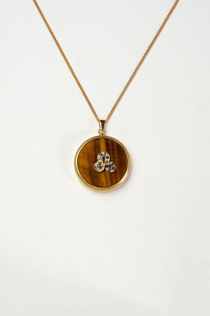 Leo zodiac pendant: tiger's eye cabochon and blue sapphire.

Amuleto de Leo: ojo de tigre cabujón y zafiro azul.