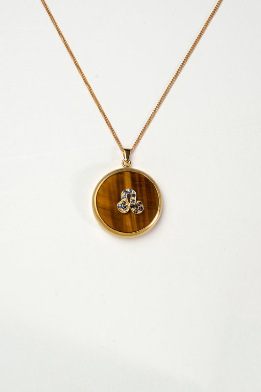 Leo zodiac pendant: tiger's eye cabochon and blue sapphire.

Amuleto de Leo: ojo de tigre cabujón y zafiro azul.
