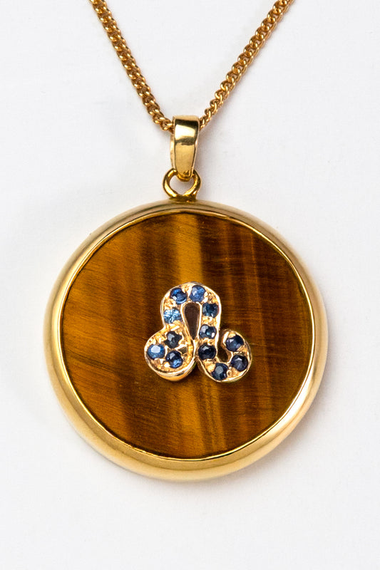 Leo zodiac pendant: tiger's eye cabochon and 14K Gold Vermeil.

Amuleto de Leo: ojo de tigre cabujón y 14K Gold Vermeil.