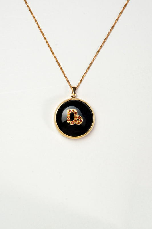 Capricorn zodiac pendant: onyx cabochon and red garnet.

Amuleto de Capricornio: ónix cabujón y granates rojos.