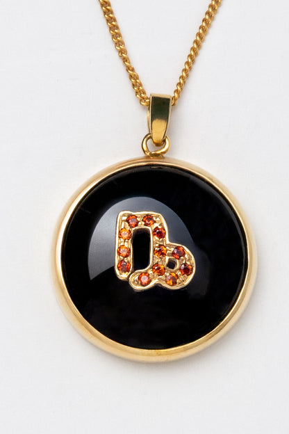 Capricorn zodiac pendant: onyx cabochon and red garnet.

Amuleto de Capricornio: ónix cabujón y granates rojos.