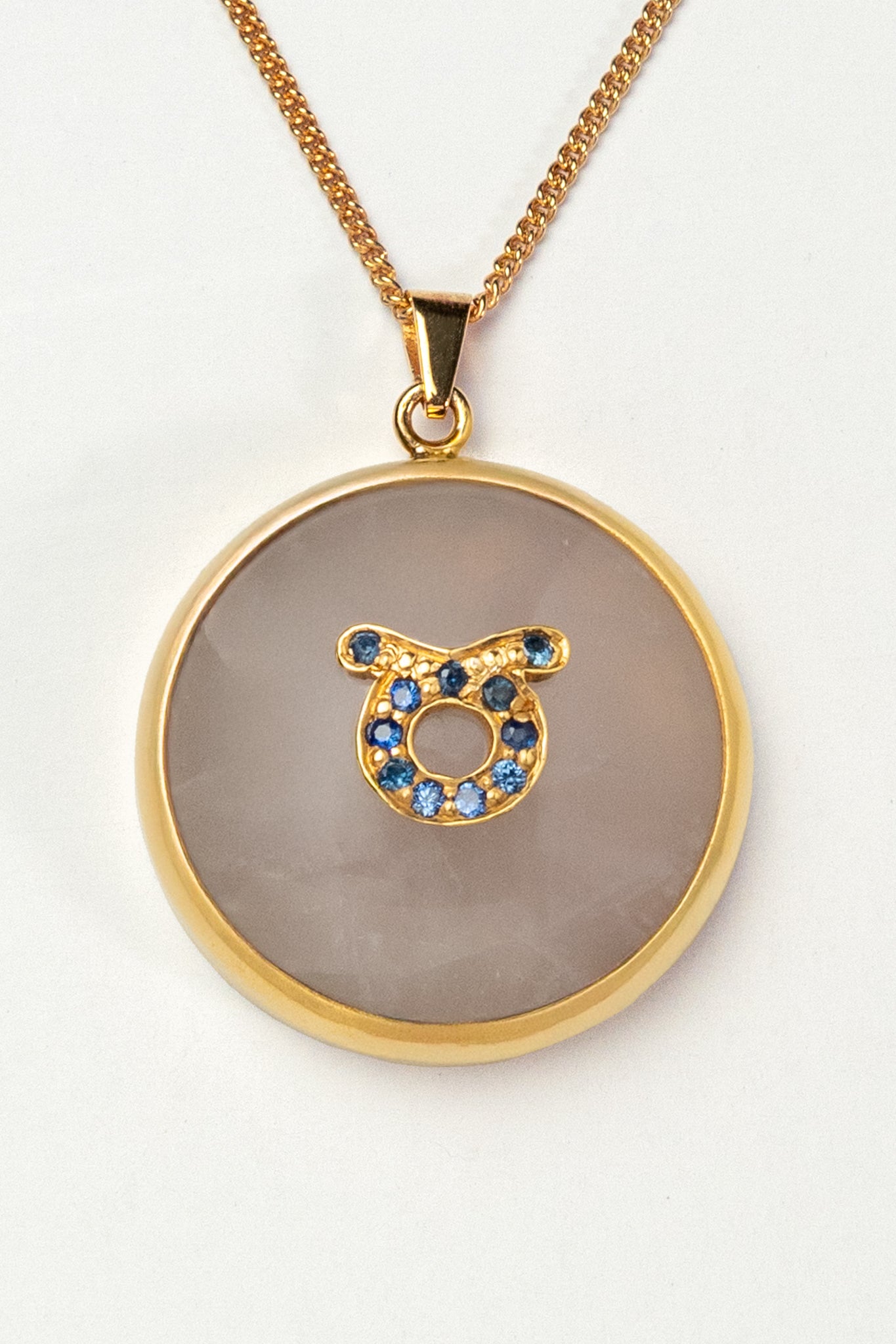 Taurus zodiac pendant: rose quartz cabochon and blue sapphire.

Amuleto de Tauro: cuarzo rosa cabujón y zafiro azul.